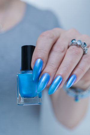 Woman's beautiful hand with long nails and light baby blue manicureの写真素材