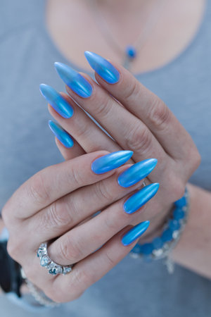 Woman's beautiful hand with long nails and bright blue manicureの写真素材