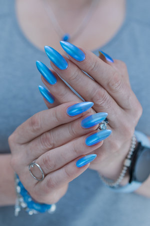 Woman's beautiful hand with long nails and light baby blue manicureの写真素材