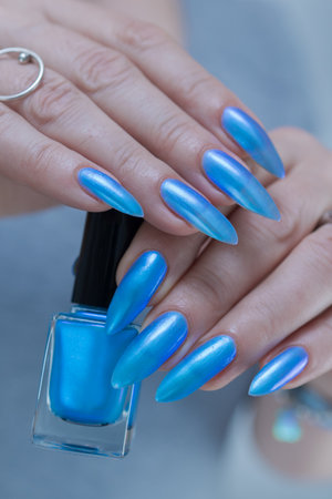 Woman's beautiful hand with long nails and baby blue manicureの写真素材