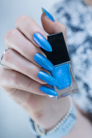 Woman's beautiful hand with long nails and light baby blue manicureの写真素材