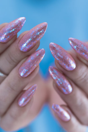 Female hands with long nails and a light pink color nail polishの写真素材