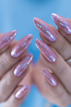 Female hands with long nails and a light pink color nail polishの写真素材