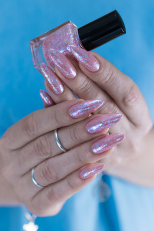 Female hands with long nails and a light pink color nail polishの写真素材