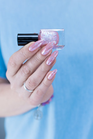 Female hands with long nails and a light pink color nail polishの写真素材