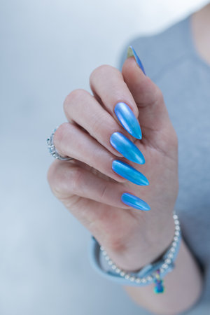 Woman's beautiful hand with long nails and bright blue manicureの写真素材