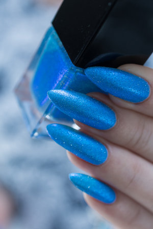 Woman's beautiful hand with long nails and bright blue manicureの写真素材