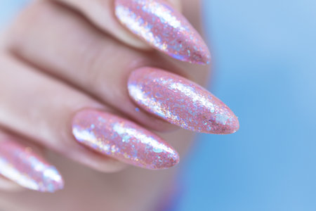 Female hands with long nails and a light pink color nail polishの写真素材