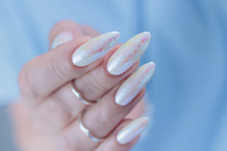 beautiful female hands with long nails light white manicureの写真素材
