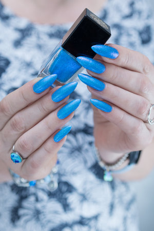 Woman's beautiful hand with long nails and bright blue manicureの写真素材