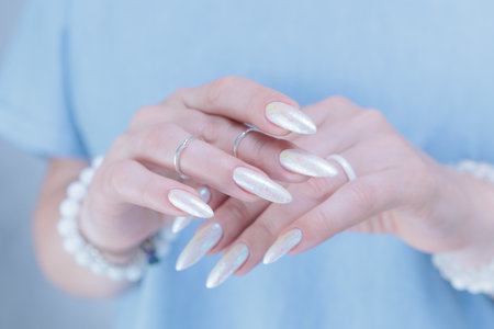 beautiful female hands with long nails light white manicureの写真素材