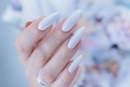 beautiful female hands with long nails light white manicureの写真素材