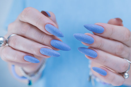 Woman's beautiful hand with long nails and bright blue manicureの写真素材