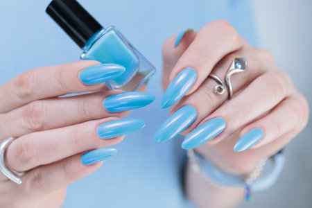 Woman's beautiful hand with long nails and baby blue manicureの写真素材