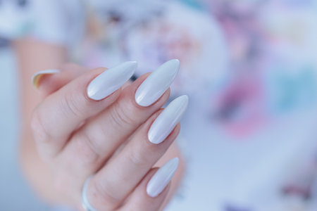 beautiful female hands with long nails light white manicureの写真素材