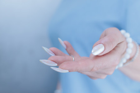 beautiful female hands with long nails light white manicure