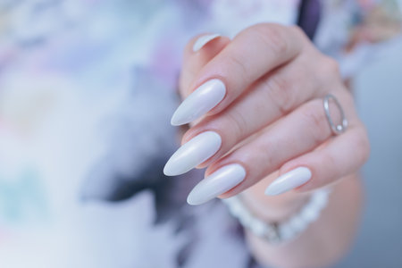 beautiful female hands with long nails light white manicureの写真素材