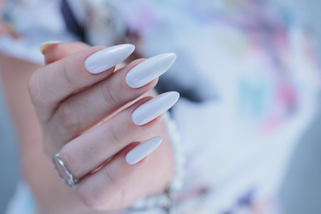 beautiful female hands with long nails light white manicureの写真素材