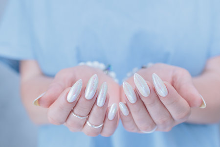 beautiful female hands with long nails light white manicureの写真素材
