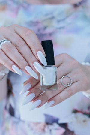 beautiful female hands with long nails light white manicureの写真素材