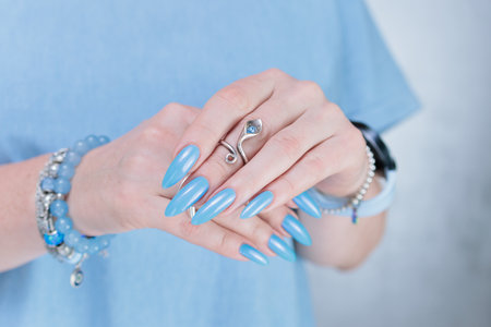beautiful hand with long nails and light baby blue manicureの写真素材