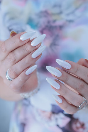 beautiful female hands with long nails light white manicureの写真素材