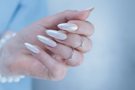 beautiful female hands with long nails light white manicureの写真素材