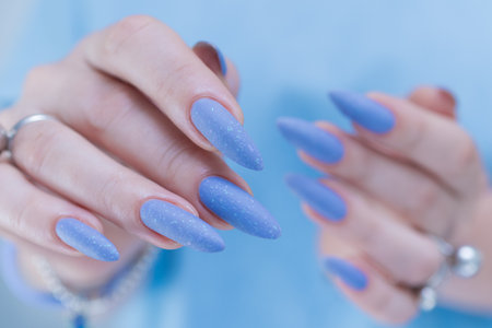beautiful hand with long nails and light baby blue manicureの写真素材