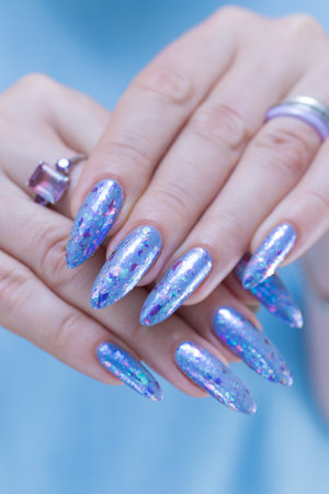 Woman's beautiful hand with long nails and bright blue manicureの写真素材