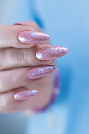 Female hands with long nails and a light pink color nail polishの写真素材