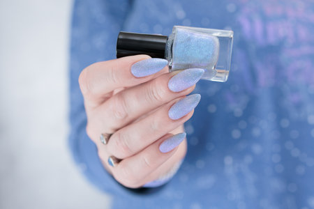 Woman's beautiful hand with long nails and light baby blue manicureの写真素材