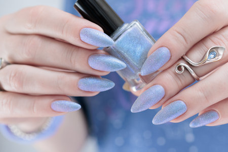 Woman's beautiful hand with long nails and light baby blue manicureの写真素材