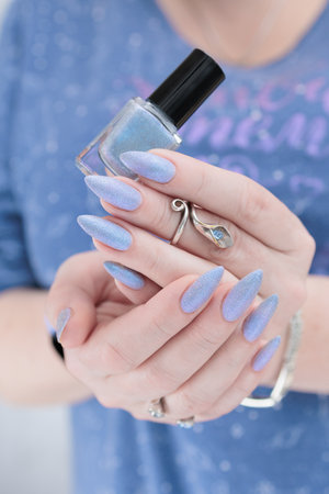 Woman's beautiful hand with long nails and light baby blue manicureの写真素材