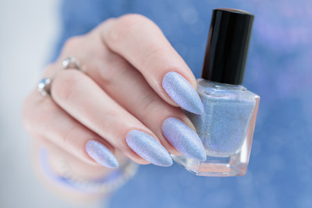 Woman's hand with long nails and light baby blue manicureの写真素材