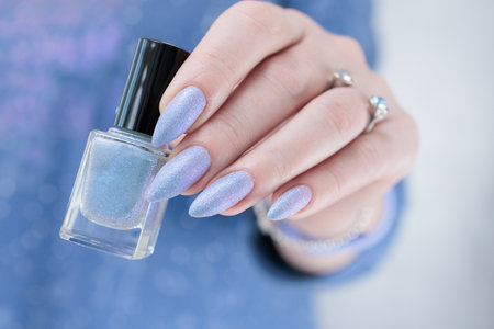 Woman's beautiful hand with long nails and light baby blue manicureの写真素材