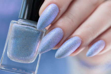 Woman's beautiful hand with long nails and light baby blue manicureの写真素材