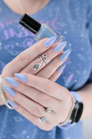 Woman's beautiful hand with long nails and light baby blue manicureの写真素材