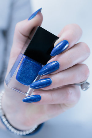Woman's beautiful hand with long nails and dark blue manicureの写真素材