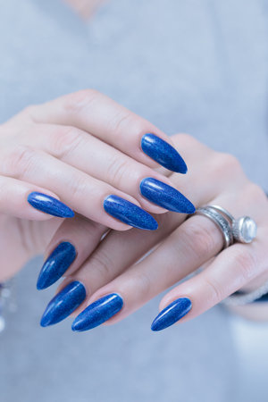 Woman's hand with long nails and dark blue manicureの写真素材