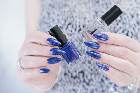 Woman's hand with long nails and dark blue manicureの写真素材