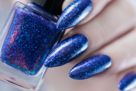 Woman's beautiful hand with long nails and dark blue manicureの写真素材