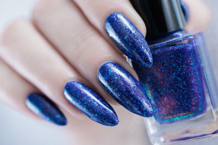 Woman's hand with long nails and dark blue manicureの写真素材