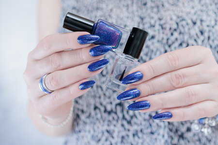 Woman's hand with long nails and dark blue manicureの写真素材