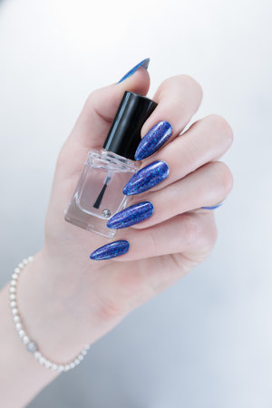 Woman's hand with long nails and dark blue manicureの写真素材