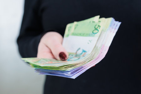 Female hands holding paper bills Belarusian rubles
