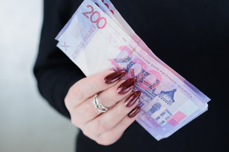Female hands holding paper bills Belarusian rublesの写真素材