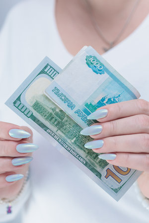 female hands holding Russian rubles and American dollar paper billsの写真素材
