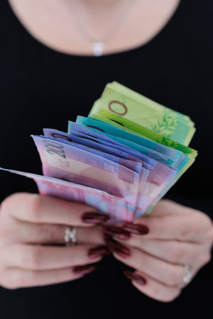 Female hands holding paper billsの写真素材