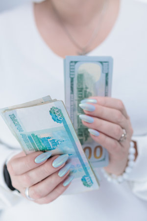 female hands holding Russian rubles and American dollar paper billsの写真素材