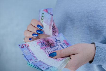Female hands holding paper bills Belarusian rubles